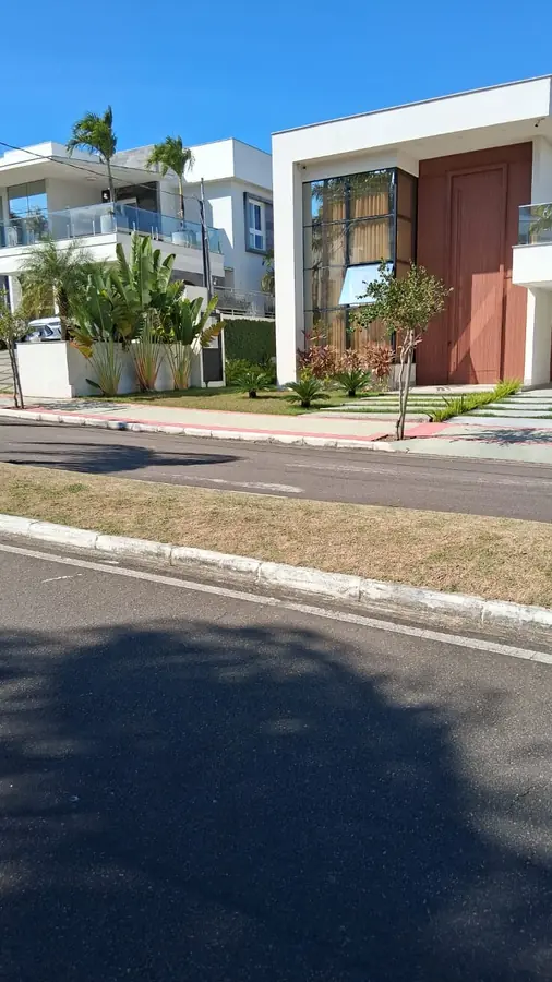 Jardim residencial com palmeiras e grama bem cuidada